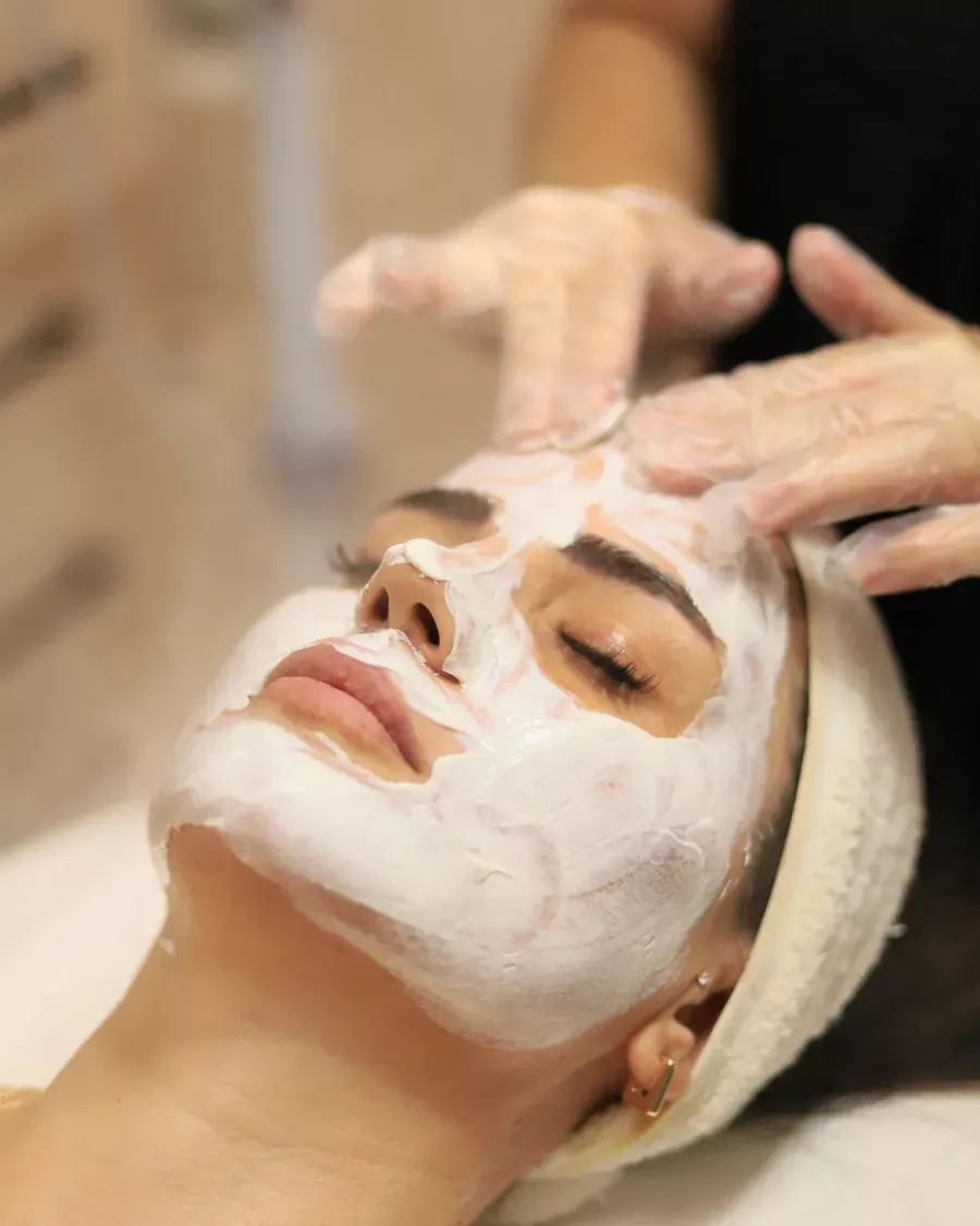 Cliente com máscara facial em sessão de cuidados com a pele